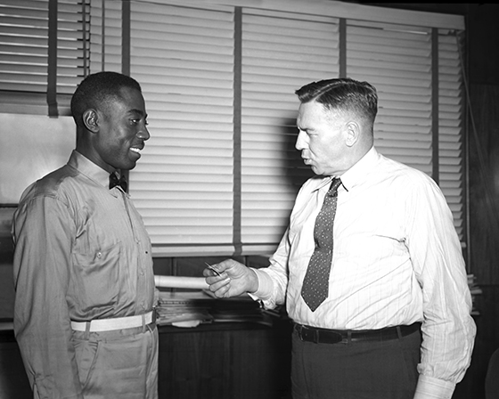 Hill receiving 10-year service pin from Woolman, 1945