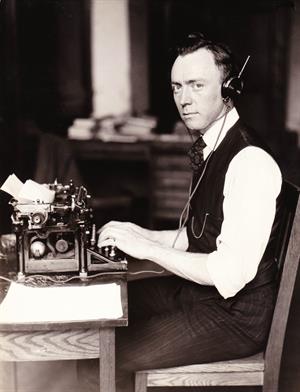 Paul F Godley with typewriter &amp; headphones